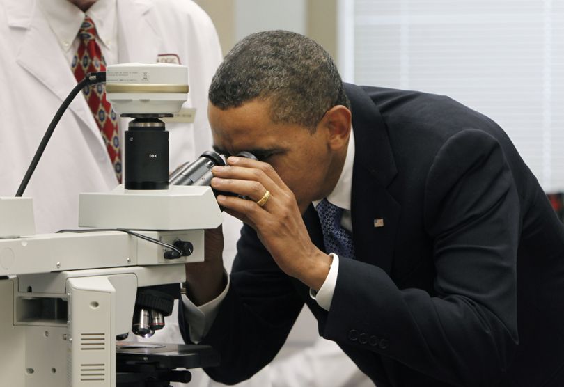 ORG XMIT: WHGH106 President Barack Obama peers into a microscope during a tour of the National Institute of Health in Bethesda,  Md., Wednesday, Sept. 30, 2009. (AP Photo/Gerald Herbert) (Gerald Herbert / The Spokesman-Review)