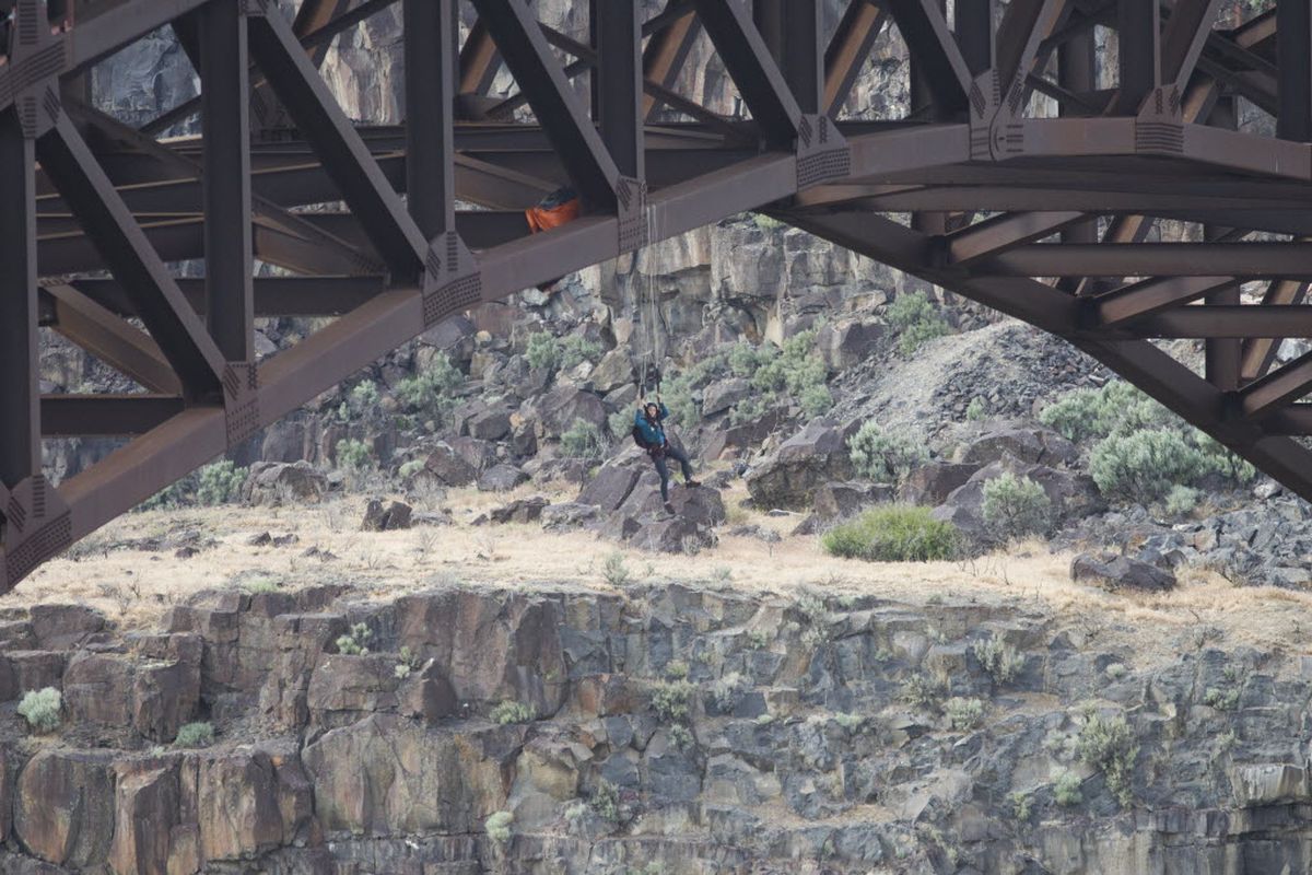 A BASE jumper hangs from her parachute on supports of the Perrine Bridge on Tuesday, May 12, 2015, in Twin Falls, Idaho. (Stephen Reiss/The Times-News via AP)