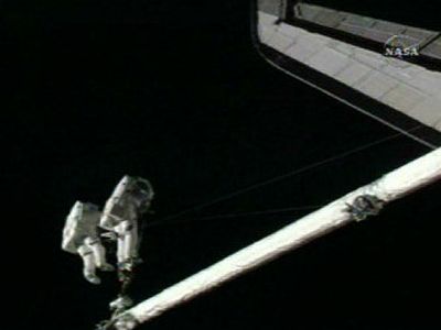 
In this image made from NASA TV, astronauts Piers Sellers, left, and Mike Fossum work side by side near Discovery's wing on a robotic arm during a spacewalk Saturday. 
 (AP / The Spokesman-Review)
