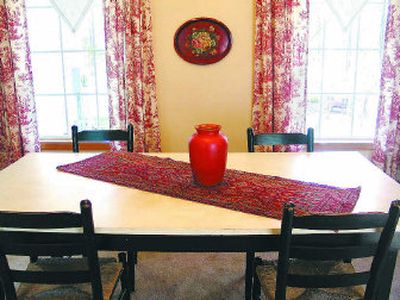 
An old work table  and vintage linen tablecloths hung as valances find new life in the dining room. 
 (Cheryl-Anne Millsap / The Spokesman-Review)