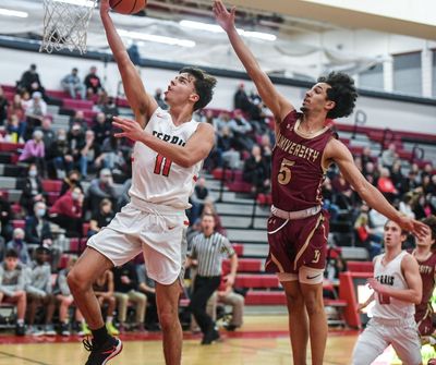 Ferris guard Ray Ray Bergersen (11) scores against visiting University guard Jeremiah Sibley (5) on Jan. 11, 2022.  (Dan Pelle)