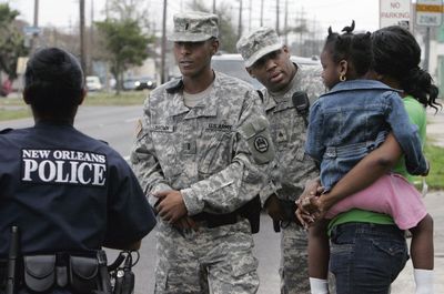 Louisiana National Guard Lt. Ronald Brown, Jr., center, and Sgt. Wayne Lewis talk with a New Orleans police officer Thursday in the 9th Ward of New Orleans.  (Associated Press / The Spokesman-Review)