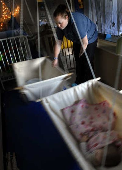 
Sarah Nevarez rocks a hammock while watching a baby fall asleep at The Cottage Childcare & Learning Center in Post Falls last week. The Cottage is taking part in a state pilot program to develop standards for child care providers. 
 (Kathy Plonka / The Spokesman-Review)