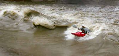 
Whitewater kayaker Brett Crawford of Arlington surfs a large wave Wednesday on the Clear Fork of the Trinity River near downtown Fort Worth, Texas. The wave, located in the new Trinity White Water Park, came with the heavy rains.
 (Associated Press / The Spokesman-Review)