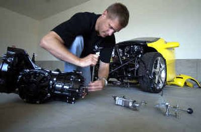 
Ron Keto prepares a transaxle for modification for the Merlin Roadster sitting behind him. Merlin Motors is starting a plant in Spokane with the working prototype of the Merlin Roadster scheduled to be running this fall. 
 (Liz Kishimoto / The Spokesman-Review)