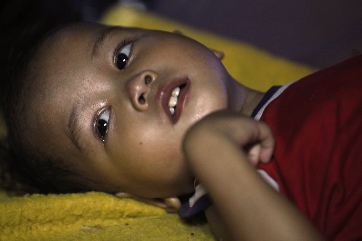 Mohammed Ansri, 2,  lies in a makeshift hospital in the Sumatran Island city of Padang, Indonesia, on Saturday. (The Spokesman-Review)