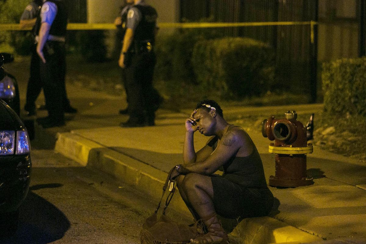 In this Aug. 7, 2016, file photo, a woman sits on the curb as police in the background investigate the scene where gunfire at a birthday party left a man dead and a woman injured. August was the deadliest month for Chicago homicides in two decades, and an analysis of the toll shows more clearly than ever that the blame lies with surging violence in a handful of the citys most impoverished neighborhoods riven by loosely organized street gangs. (Ashlee Rezin / Chicago Sun-Times via AP)