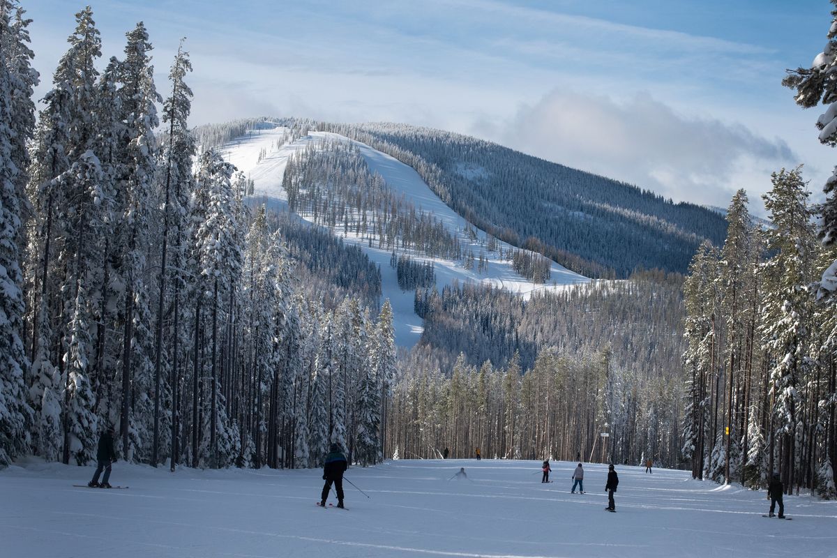 Skiers and boarders head toward Lookout Pass’ newest chairlift on Saturday. The new terrain on Eagle Peak is visible in the background.  (Eli Francovich/The Spokesman-Review)