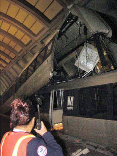 
One subway car lies atop another on Metro's Red Line at the Woodley Park-National Zoo station after a collision that injured at least 20 people Wednesday in Washington, D.C. An empty subway train rolled backward into a train full of passengers at the station.
 (Associated Press / The Spokesman-Review)
