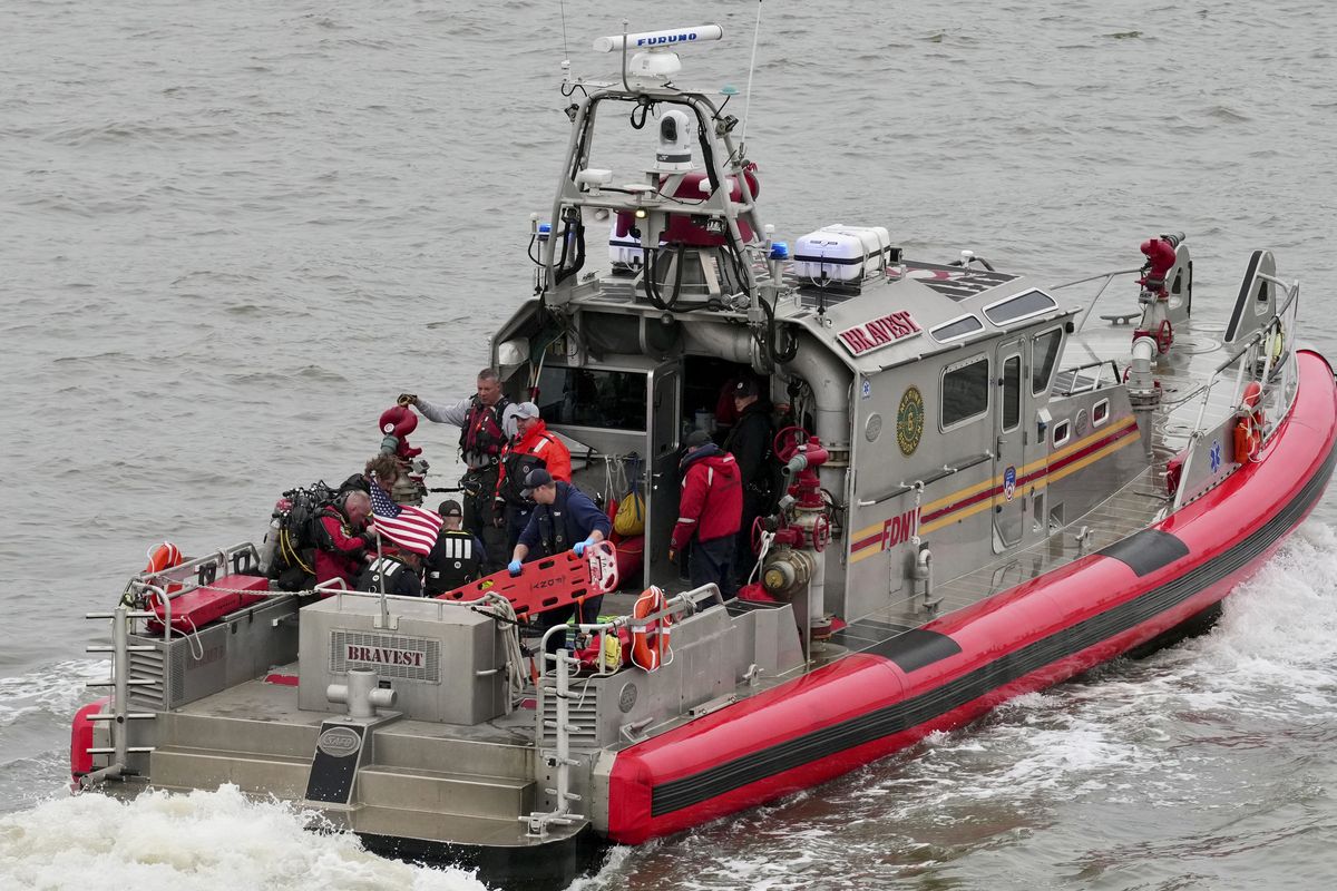 New York Fire Department divers on a boat near the scene of a helicopter crash Thursday on the Hudson River near Manhattan, N.Y. Police boats and other rescue vessels surrounded what appeared to be an overturned helicopter floating in the river. Witnesses on social media reported having seen a helicopter in distress before it plunged into the water. (Adam Gray/The New York Times)