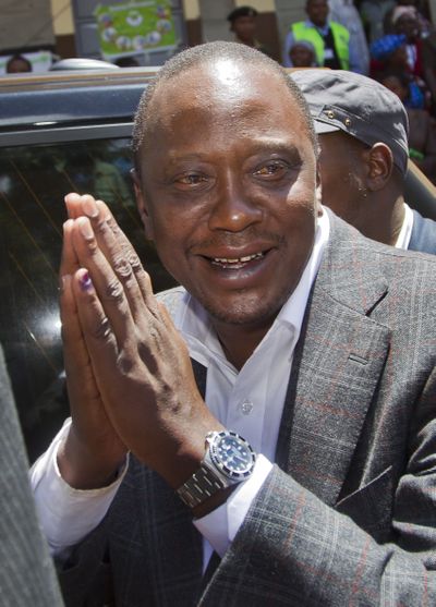 Kenyan presidential candidate Uhuru Kenyatta gestures to queuing voters. (Associated Press)