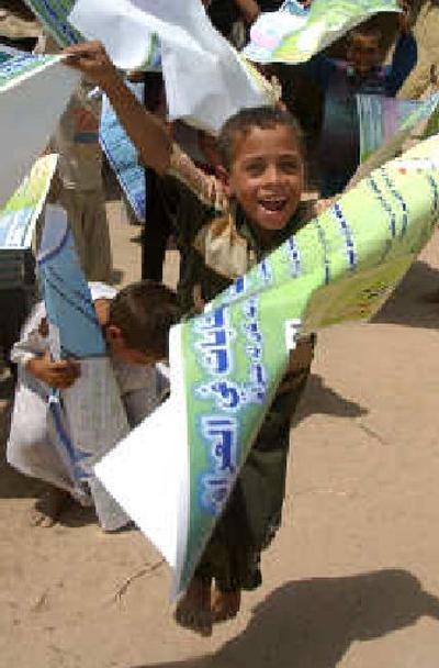 
A boy plays with posters explaining the Oct. 15 constitution election on Monday. 
 (Associated Press / The Spokesman-Review)