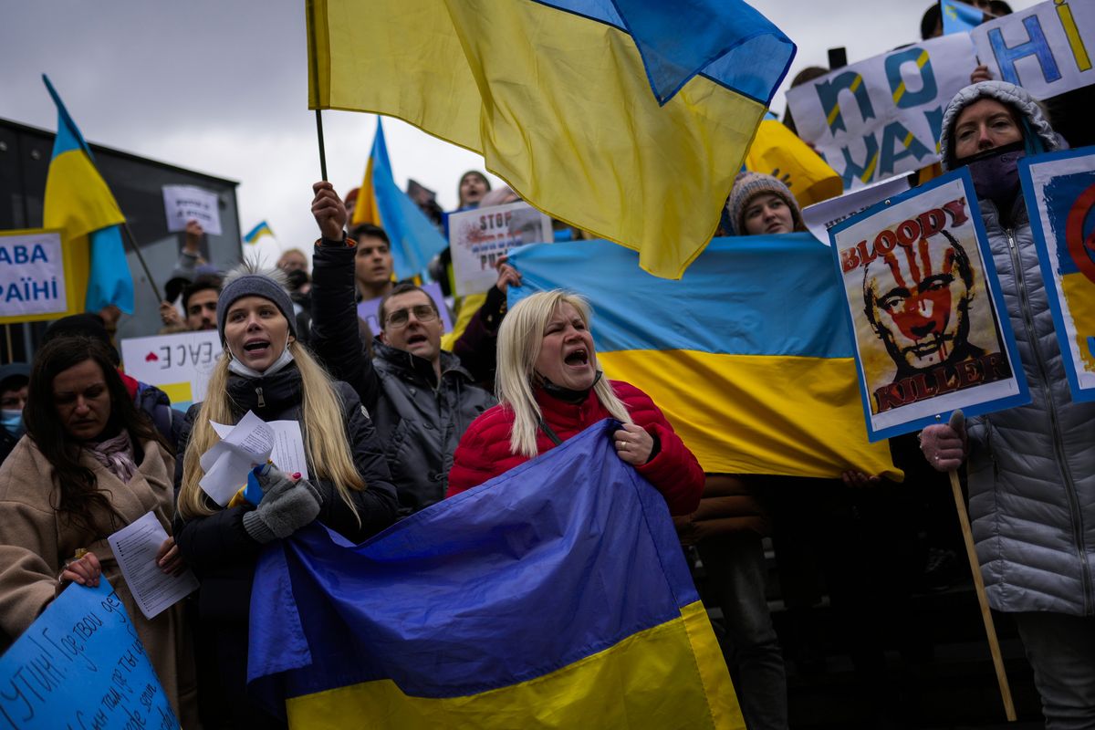 Pro-Ukrainian people wave Ukrainian flags as they shout slogans during a protest against Russia