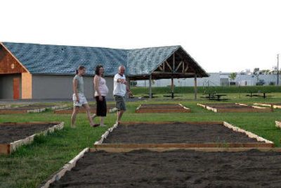 
Northeast Spokane residents Esther Gaines, Laura Warren and Lloyd Gaines walk through the community garden under construction at Andrew Rypien Field.
 (Evan Jensen / The Spokesman-Review)