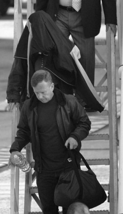
Astronaut Lisa Marie Nowak hides under a coat as she  and chief astronaut Steve Lindsey   arrive   in Houston on Wednesday. 
 (Associated Press / The Spokesman-Review)