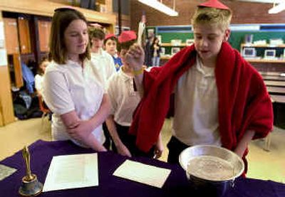 
As Paige Porter, 13, observes, Tucker Clarry, 14, performs his cardinal duties by voting for a new pope Friday at All Saints Catholic School. The eighth-graders held a mock election for a new pope.
 (Colin Mulvany / The Spokesman-Review)