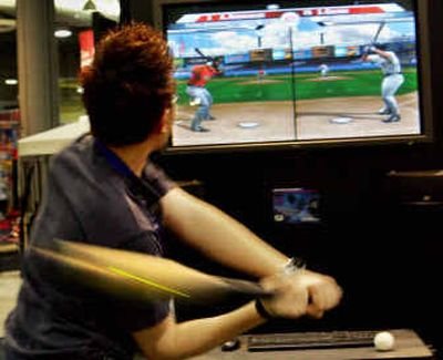 
A visitor  swings at QMotions- Baseball  video game  last week  at the Electronic Entertainment Expo in Los Angeles.  
 (Associated Press / The Spokesman-Review)