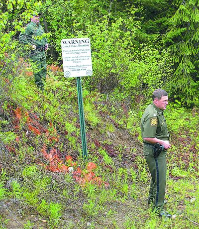 U.S. Border Patrol agents Shannon Clift, left, and Lonnie Moore  stand on the U.S.-Canadian border near Metaline Falls, Wash., last week.  (Associated Press)