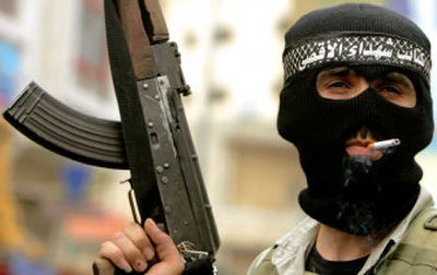 
A member of the Al Aqsa Martyrs' Brigades stands watch during a demonstration against the speech of Hamas leader Khaled Mashall,  in the West Bank town of Ramallah, Saturday. 
 (Associated Press / The Spokesman-Review)