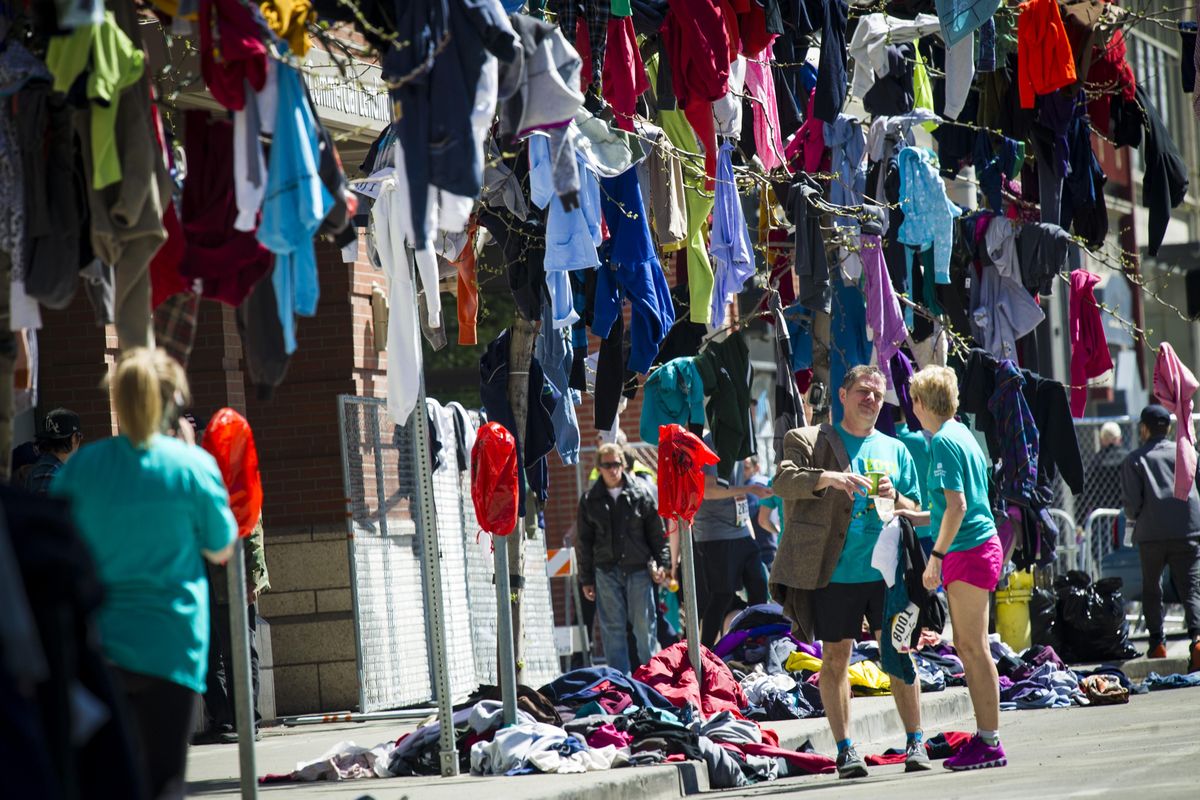 Tom Havey from Portland tries on a discarded sport coat after finishing this year’s Bloomsday race with his wife Jennie. This is Tom’s 36th Bloomday race and Jennie’s 13th. (Colin Mulvany / The Spokesman-Review)