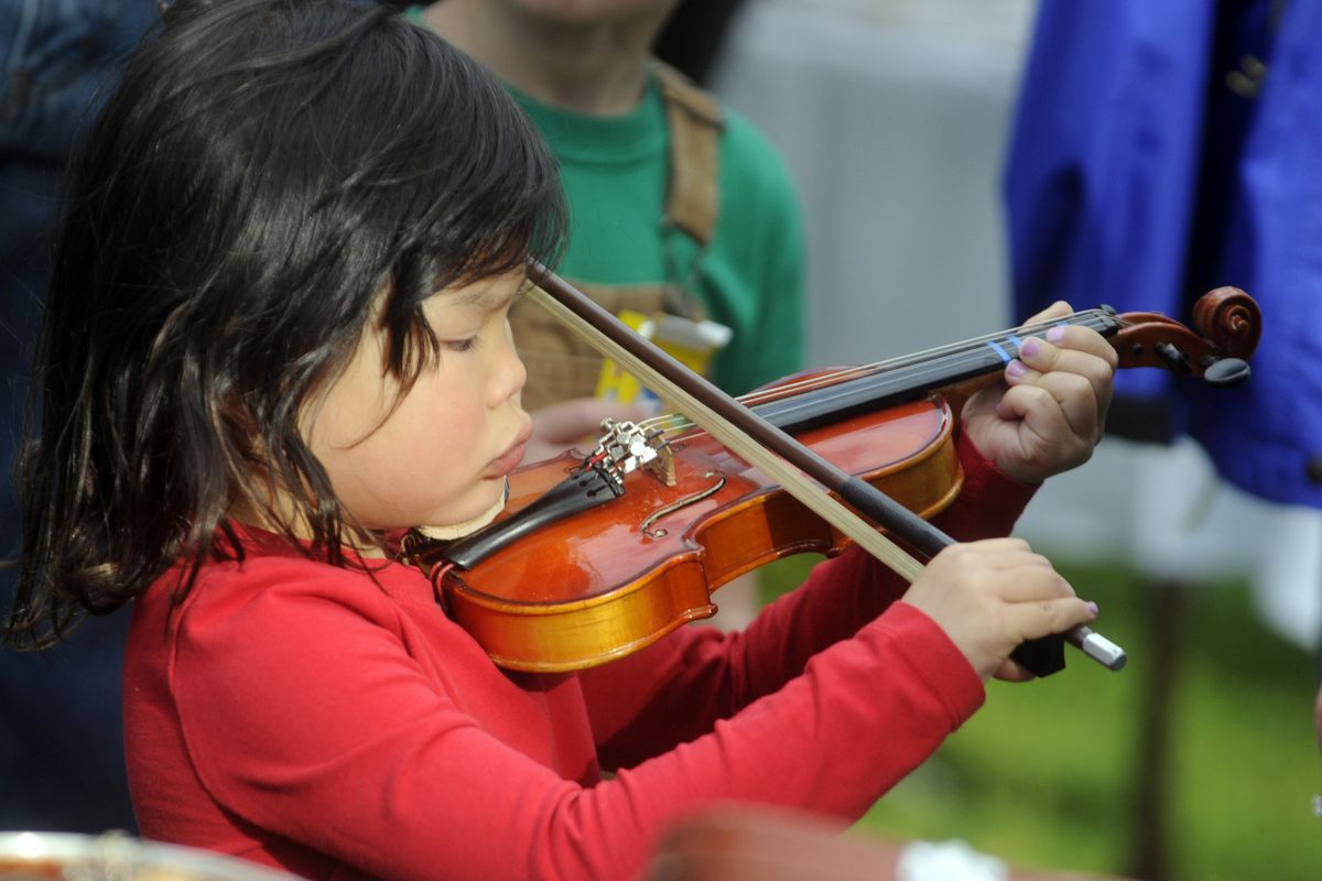 Four-year-old Leyna Doty,  of Seattle, takes a crack at the violin at the Spokane Symphony’s Instrument Petting Zoo. (The Spokesman-Review)