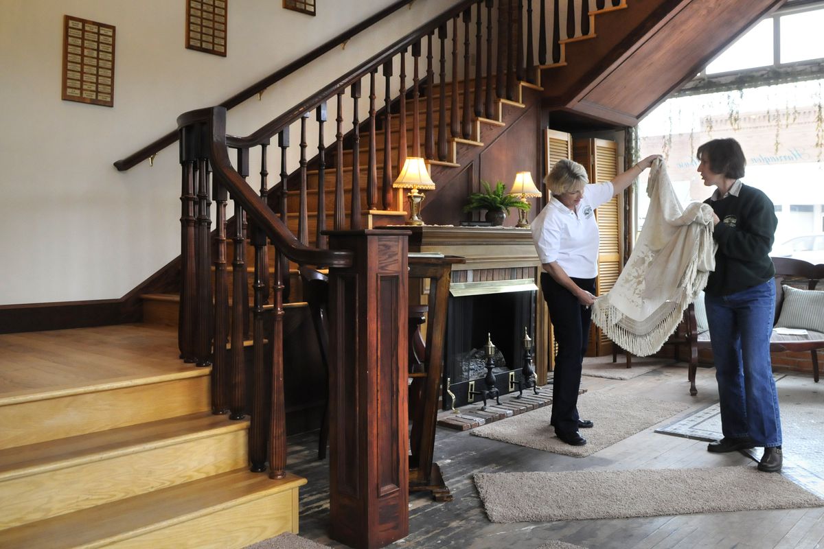 Linda Wagner and Karen Robertson, right, view a shawl that was worn by a bridesmaid in the wedding of Abraham Lincoln and Mary Todd on Nov. 4, 1842. It has been donated for display in the lobby of the Harrington Opera House. The lobby features a new wooden staircase. At top: An exterior shot of the historic Opera House.