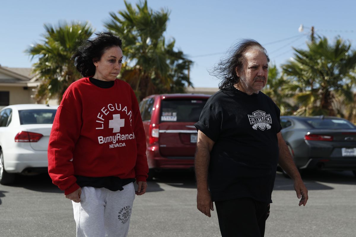 Ron Jeremy, right, and Heidi Fleiss walk out of the Love Ranch brothel, Tuesday, Oct. 16, 2018, in Pahrump, Nev. The woman dubbed the "Hollywood Madam" when she was accused in the mid-1990s of running a high-priced Los Angeles prostitution ring says she