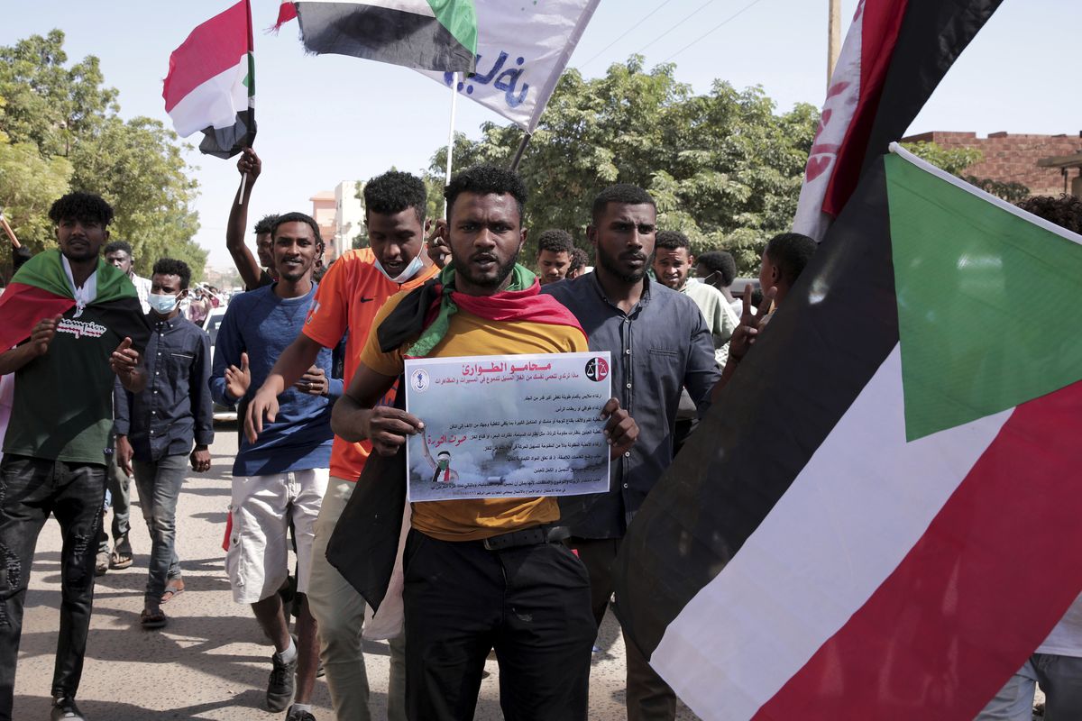 People chant slogans during a protest to denounce the October military coup, in Khartoum, Sudan, Saturday, Dec. 25, 2021. Sudanese security forces fired tear gas to disperse protesters as thousands rallied since earlier in the day, even as authorities tightened security across Khartoum, deploying troops and closing all bridges over the Nile River linking the capital with its twin city of Omdurman and the district of Bahri, the state-run SUNA news agency reported.  (Marwan ali)