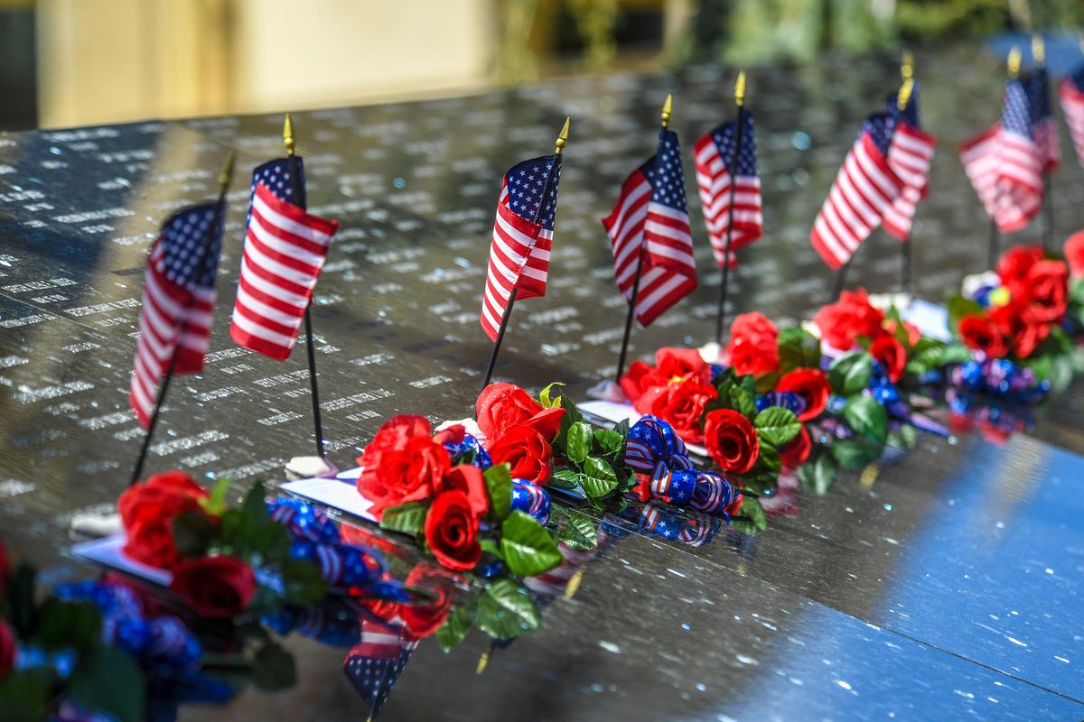 Flags and flowers mark the names of fallen at the Law Enforcement Officers Memorial Project before the 33 Annual ceremony, Tuesday, May 4, 2021, at the Public Safety Building in Spokane.  (DAN PELLE/THE SPOKESMAN-REVIEW)
