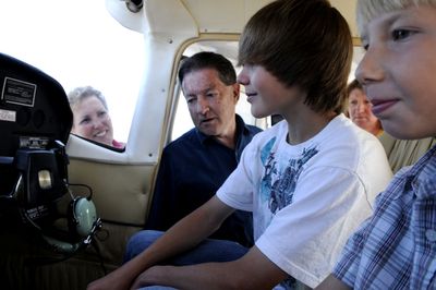 SOARING member Tyler Jordan, 14, center and his brother Trevor, 9, check out the controls of a Cessna 182 at the Northern Sky Air Center at the Coeur d’Alene Airport on  July 15. Watching in the background are, from left, their mother Cari Jordan, SOARING founder Joe McCarron  and Northern Sky Air Center owner Jay Burdeaux. (Kathy Plonka / The Spokesman-Review)