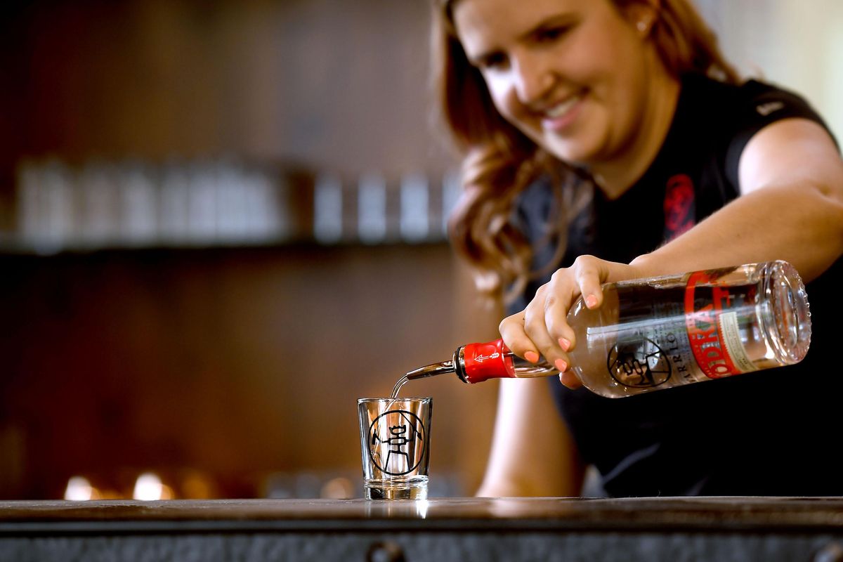 Kayla Clemson pours Warrior vodka at the distillery in Spokane on Tuesday, July 3, 2018. (Kathy Plonka / The Spokesman-Review)