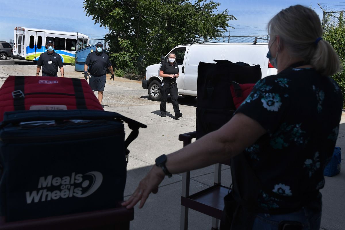 STA paratransit drivers, from left, Bryan Dornbos, Alex Henry and supervisor Angela Brown walk toward food service director Jerri Horton of Greater Spokane County Meals on Wheels to help with delivery on June 25.  (Kathy Plonka/The Spokesman-Review)