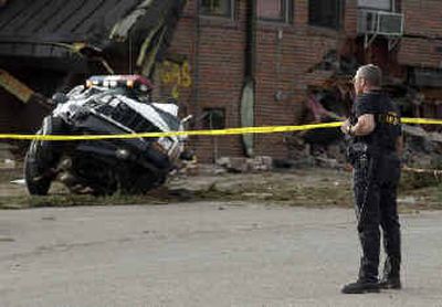 An unidentified sheriff's deputy looks at the damage to the Granby City Hall and a police vehicle after a man reportedly angry at local government over a zoning dispute tore through Granby, Colo., Friday, in an armored bulldozer.
(Associated Press / The Spokesman-Review)