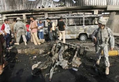 
U.S. soldiers stand guard as residents inspect damaged vehicles at the scene where a car bomb exploded  in northwestern Baghdad on Sunday, killing at least 10 people. Associated Press
 (Associated Press / The Spokesman-Review)