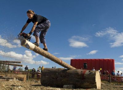 
Erin LaVoie, of Spokane, cuts the end off a log with a chain saw as she competes in a timed event at the first LoggingFest lumberjack competition, held in conjunction with the Spokane Valleyfest, at Mirabeau Park on Saturday. LaVoie has competed for five years in similar events and is a model for Stihl chain saws. 
 (Ingrid Lindemann / The Spokesman-Review)