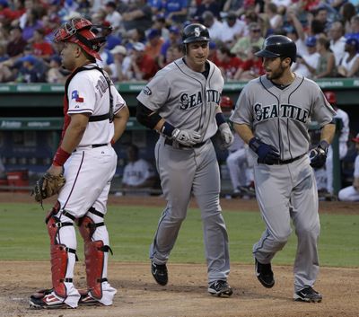 Mariners’ Mike Carp, center, and Dustin Ackley head (Associated Press)