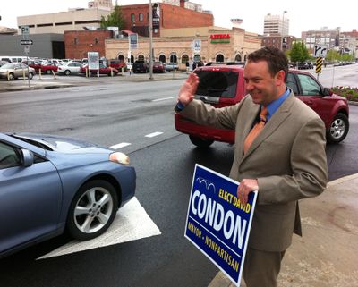 Courting voters: David Condon waves to cars headed into the parking area at the downtown Doubletree Hotel, where he addressed attendees at the kickoff breakfast for his campaign for Spokane mayor on Tuesday. (Jonathan Brunt)