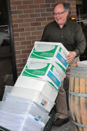 Glenn Avery of Modernize Washington wheels boxes of petitions for I-1100 into the Secretary of State's office on June 23, 2010
