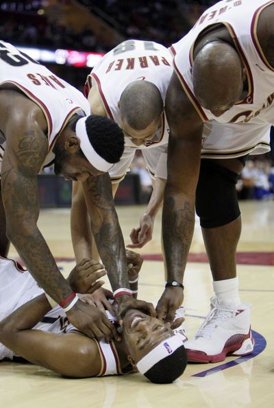 Cavs’ LeBron James, left, Anthony Parker, center, and Shaquille O’Neal tickle Daniel Gibson after he was knocked to the floor.   (Associated Press)