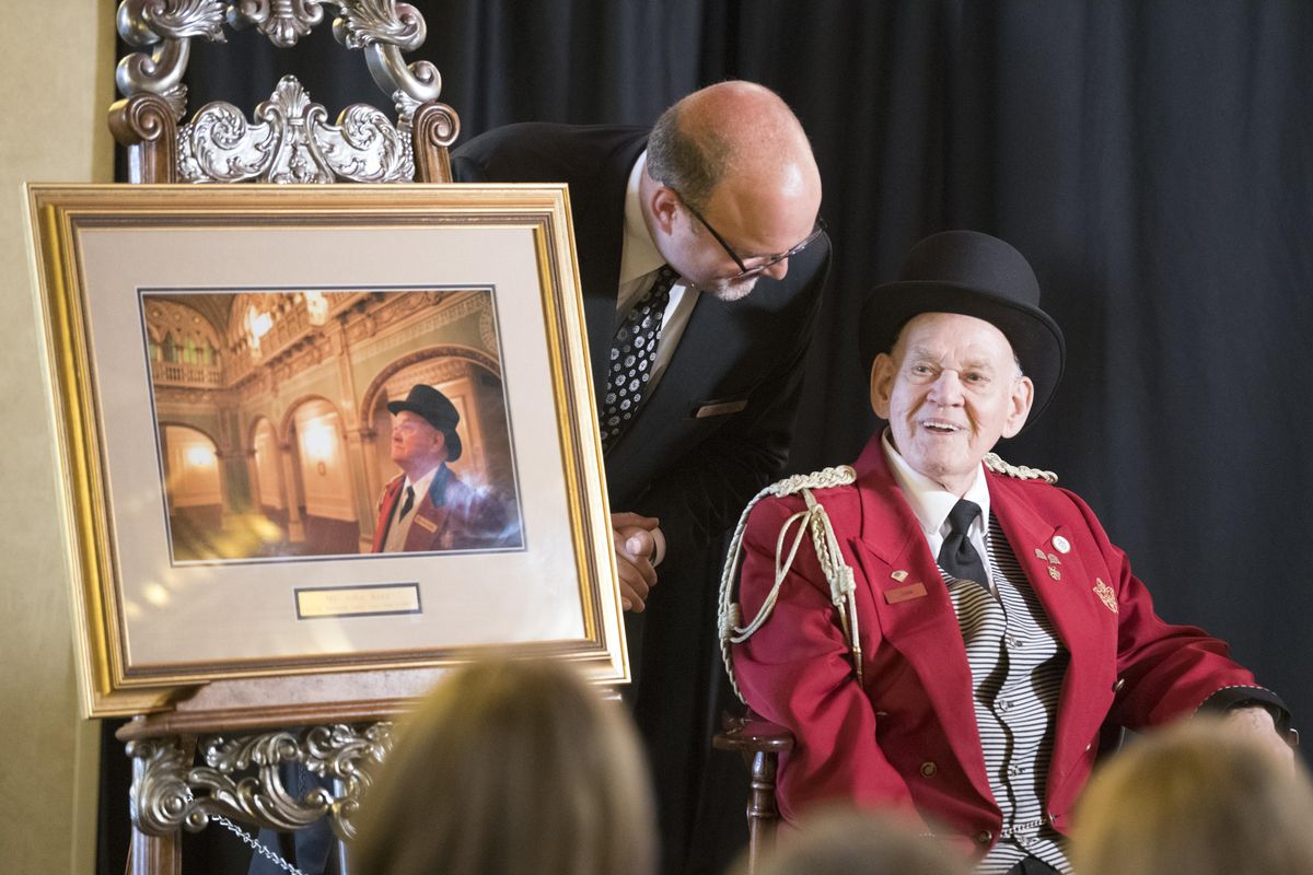 Longtime Davenport Hotel door man John Reed, seated, shares a chuckle with Matt Jensen, Director of Sales and Marketing for the Davenport Hotels, at a ceremony to recognize that Reed has been at the Davenport Hotel for 75 years as of Thursday, June 1, 2017. Though he took time off for college, Reed was hired as a bus boy by Louis Davenport June 1, 1942 and is the hotels longest serving employee by far. To honor him, the hotel named a boardroom after Reed and will hang the photograph at left in the room. (Jesse Tinsley / The Spokesman-Review)