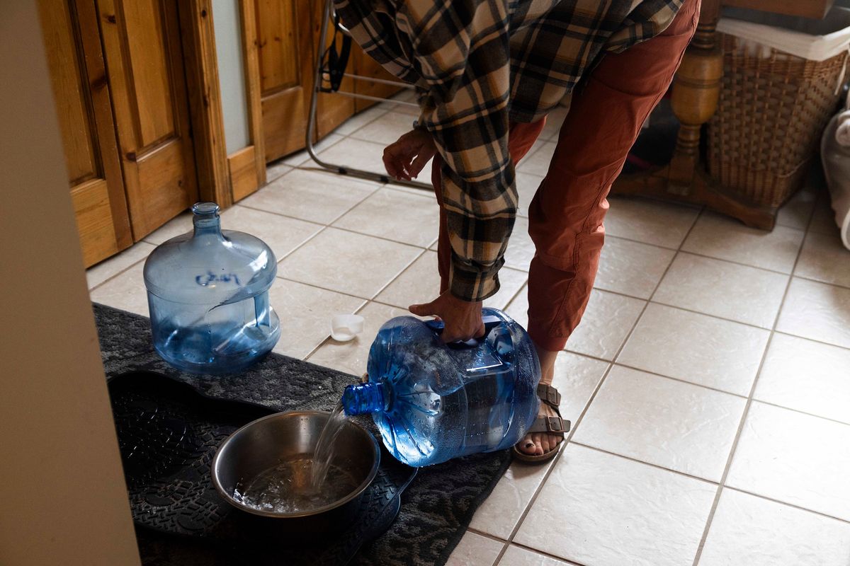 Using the water provided by the Air Force, Marcie Zambryski fills bowls up for her two boxers Livie and Louie. Her home is near Deep Creek, eight miles away from the Fairchild Air Force Base. (Daniel Kim/The Seattle Times/TNS)