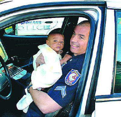 
Officer Kurt Vigessa holds an infant found Wednesday in Liberty Park. 
 (Photo courtesy of the Spokane Police Department / The Spokesman-Review)