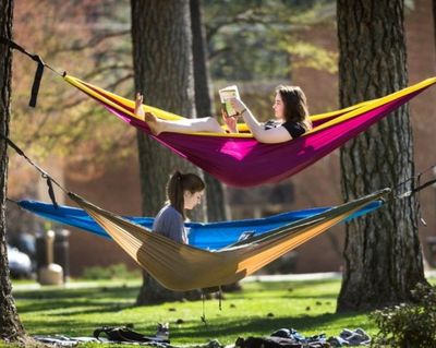 Whitworth University students Melia Deters, top, and Skyler Noble, take advantage of the warm weather to study in their hammocks strung between pine trees on campus, April 2015, in Spokane. (Colin Mulvany/SR file photo)
