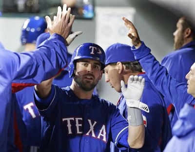 Texas Rangers’ Brett Nicholas is greeted in the dugout after he scored a run in the seventh inning of a baseball game against the Seattle Mariners, Monday, April 11, 2016, in Seattle. (Ted S. Warren / Associated Press)