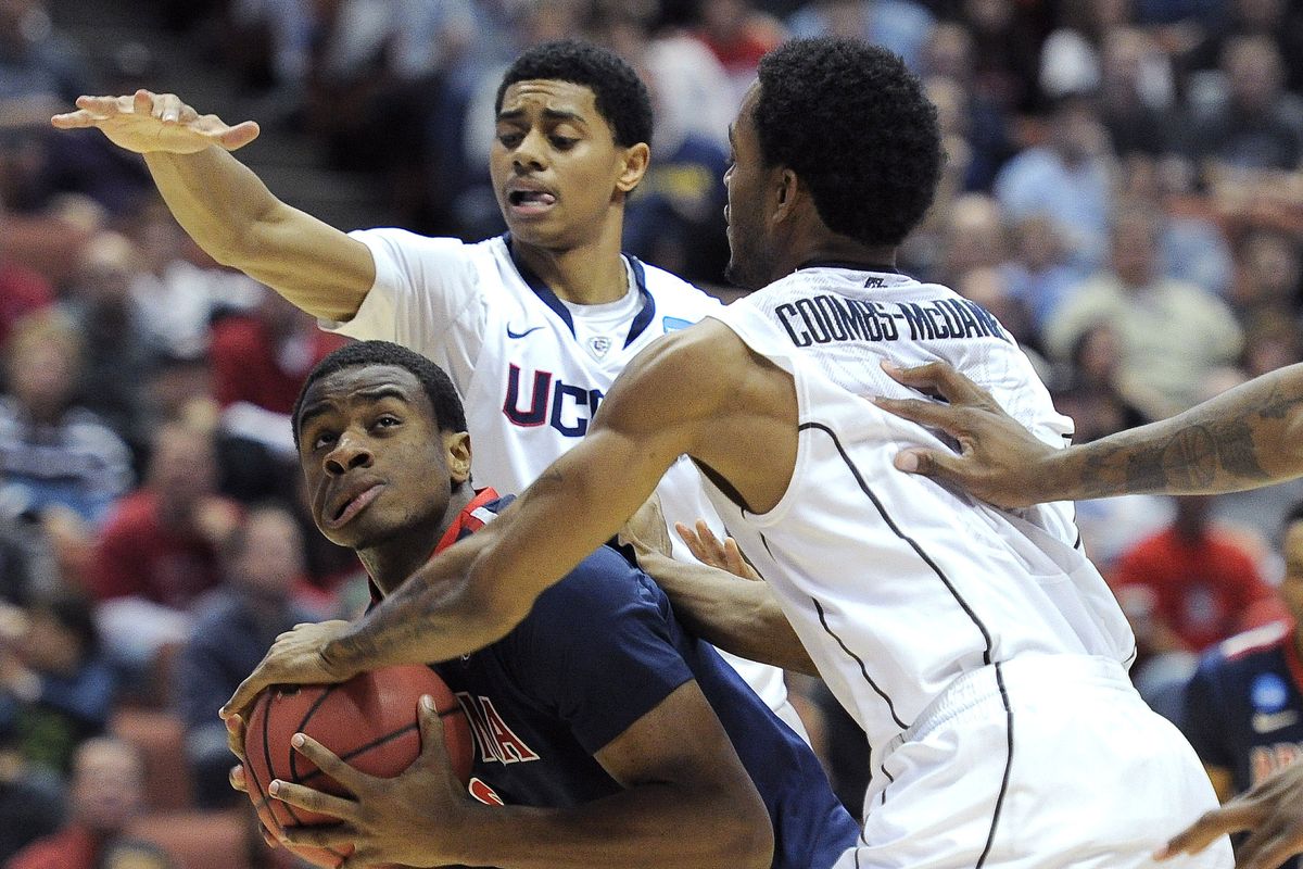 Connecticut’s Jamal Coombs-McDaniel and Jeremy Lamb, center, fight Arizona’s Kevin Parrom for the ball. (Associated Press)