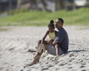 Barack Obama sits on Kailua Beach in Kailua, Hawaii, last summer with his daughter Sasha. (The Spokesman-Review)