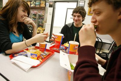 McClatchy TribuneBorah High School students, from left, Katy Sword, 17, Lane Wade, 15, and Tucker Nelson, 18, have a bite to eat after band practice in Boise. Sword works two part-time jobs to afford food, gas, clothes and the expenses that come with being in the high school band. (McClatchy Tribune / The Spokesman-Review)