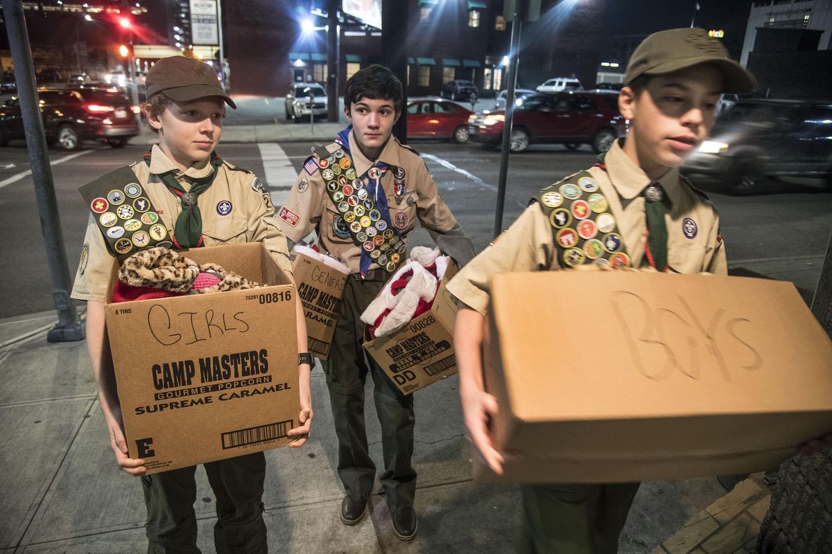 Boy Scouts from Troop 2208, from left, Sam Hanson, Cooper Cervelli and Colby Burris, carry 40 Christmas stockings into Crosswalk teen shelter, Monday, Dec. 11, 2017, in Spokane. Twenty stockings contained gifts for boys and the other 20 had gifts for girls. (Dan Pelle / The Spokesman-Review)