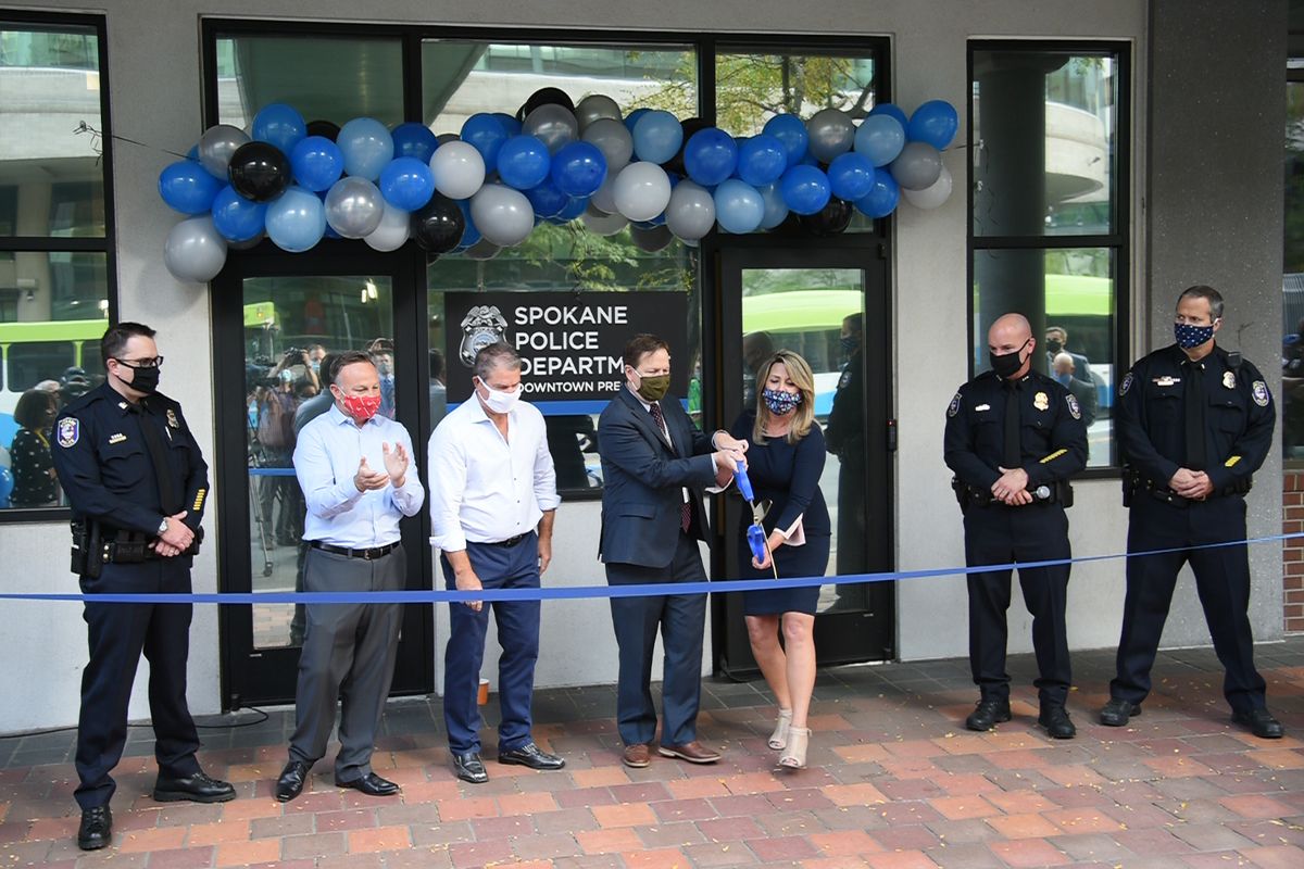 (from left) SPD Capt. Dave Singley, Downtown Spokane Partnership CEO and President Mark Richard, DSP Chair Dave Black, City Council member Breean Beggs, Mayor Nadine Woodward, SPD Chief Craig Meidl and SPD Lt. Steve Braun cut the ribbon on the new police precinct downtown in the 700 block of West Riverside Avenue Tuesday, Sept. 22, 2020.  (Jesse Tinsley/THE SPOKESMAN-REVIEW)