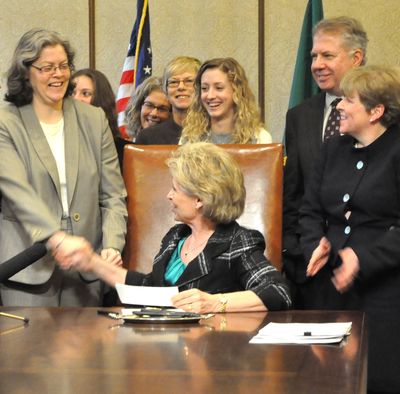 Gov. Chris Gregoire congradulates Rep. Laurie Jinkins, D-Tacoma, for passage of a bill she sponsored extending domestic partnership rights to couples who have a domestic partnership or same-sex marriage in another state. (Jim Camden/The Spokesman-Review)